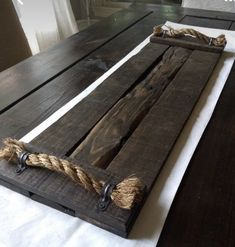 a wooden table with rope on it and a window in the backgroup