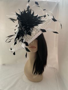 Introducing our stunning white sinamay wide brim saucer tilt hat adorned with playful black polka dots, perfect for adding a touch of whimsy to any ensemble and social event. Crafted with meticulous attention to detail, with two large handcrafted blooming feather flower and long cascading floating feathers. This hat boasts a classic wide brim silhouette, offering both style and sun protection. The sinamay material lends a lightweight and breathable feel, ideal for all-day wear. Each feather flower is carefully hand-applied with striking tips , ensuring a unique and charming look that will turn heads and captivate wherever you go. Whether you're attending a garden party, a wedding, Tea party, Women's church convention or a day at the races, this hat is sure to make a statement. Not only is White Adjustable Top Hat For Races, White Fitted Top Hat With High Crown, White Fitted High Crown Hat, White Fitted Fascinator For Royal Ascot, White Top Hat With Short Brim For Party, Fitted White Brimmed Costume Hat, White High Crown Top Hat For Party, White Fitted Hat With Pinched Crown, White Wide Brim Summer Headpiece