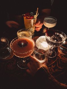 a table topped with glasses filled with different types of drinks