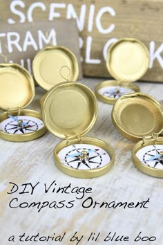 several small gold pocket watches sitting on a table with the words diy vintage compass ornament below them