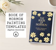 the book of mormon painting templates is next to a cup of coffee and flowers