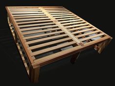 a wooden bed frame sitting on top of a black floor