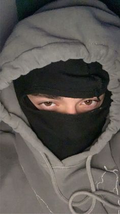 a person wearing a black mask and hood