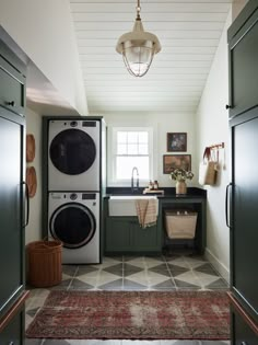 a washer and dryer sitting in a kitchen next to each other on top of a rug