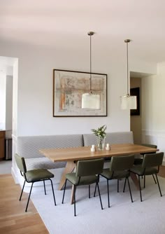 a dining room table with four chairs and a bench in front of the couches