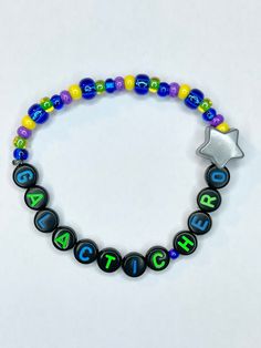 Have you ever gotten the perfect score of 999,999? Are you a natural at defeating the evil emperor? If so this bracelet is perfect to showcase your skills! Galactic Hero beaded stretch bracelet with a large Star bead charm is definitely better than a sticker!  Bracelets are available in a variety of lengths.  Pick your custom length from the drop down menu below.  All our bracelets are made with quality in mind.  With that being said, all bracelets should be treated with care while putting on, w Space Kandi, Space Bracelets, Star Wars Kandi Bracelet, Adjustable Beaded Bracelets For Fandom Gifts, Disneyland Beaded Bracelet, The Perfect Score, Apple Watch Bands Fashion, Disney Bracelet, Galactic Heroes