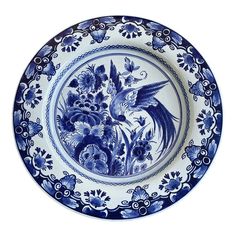 a blue and white plate with flowers and birds on the rim, isolated against a white background