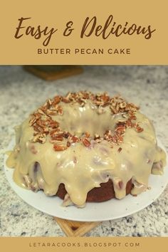 a bundt cake with icing and pecans on top sitting on a plate