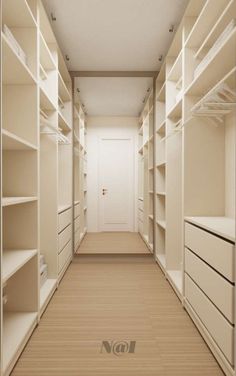 an empty walk - in closet with white shelving and wooden flooring is shown