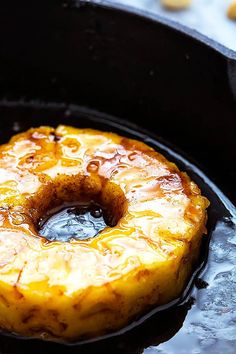 a pineapple upside down in a cast iron skillet with oil on the bottom