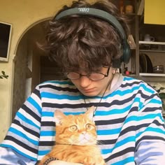 a person wearing headphones holding a cat