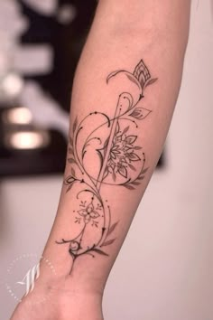 a woman's arm with a flower tattoo on it