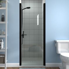 a white toilet sitting next to a shower in a blue walled bathroom with shelves on the wall