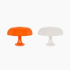 an orange and white mushroom shaped object sitting next to each other on a white surface