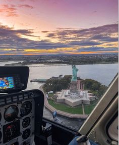 a view from the cockpit of a plane looking at an island and statue of liberty