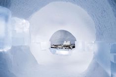 an igloose with white walls and ice formations on the floor, filled with snow