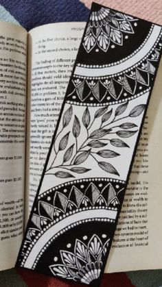 an open book with black and white designs on it