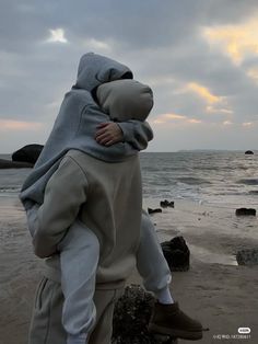 a person in a shark costume walking on the beach with their back to the camera