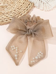 two bows with pearls on them sitting next to a straw hat and some other items