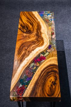 a wooden table sitting on top of a carpeted floor next to a gray wall