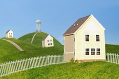 two houses on top of a green hill