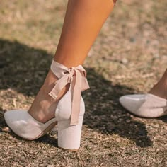 the legs and ankles of a woman wearing high heeled shoes with bows on them