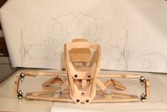 a wooden snowmobile sitting on top of a white table next to a drawing board