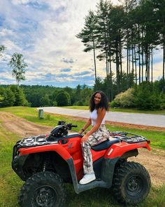 a woman sitting on top of an atv