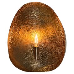 a light that is sitting on top of a wall mounted fixture with a candle in the middle