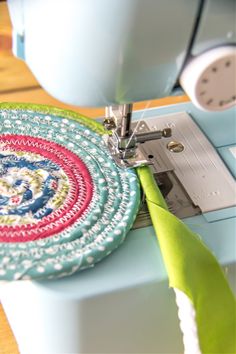 a close up of a sewing machine with a piece of fabric on the table next to it