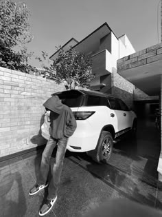 a man riding a skateboard next to a white car