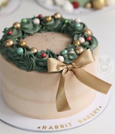 a cake decorated with green and gold decorations on top of a white table cloth covered plate