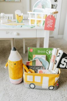 a yellow and white container filled with items on top of a floor next to a table