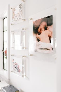 a baby's photo hangs on the wall next to a bench in a white room