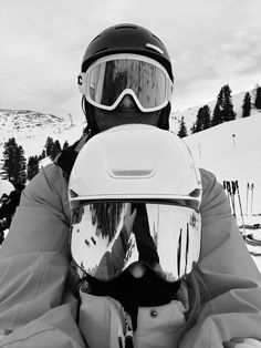 a person with skis and goggles sitting in the snow