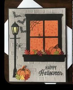 a halloween card with a window and pumpkins