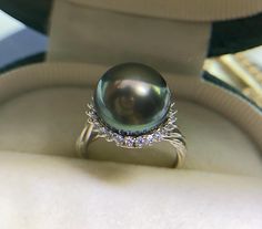 Classic Big Tahitian Green Pearl Ring, 12.2mm, Intense Green Color, Very High Luster. Sterling Silver S925 with sparkling cubic zircons, Very Well made and Comfortable to wear. Open End Ring, fits US Size 5-9.  Classic and Elegant   Lustrous Beauty   Super Value!  Pearl ★ Pearl: Genuine Tahitian Pearl, saltwater ★ Size: 12.2mm ★ Shape:  Near Round ★ Color: Natural untreated, Intense Green Color, Stunning ★ Luster: Very High Luster, Wonderful ★ Surface: Nice, Baby smooth and Mirror Like, very lightly spotted, Mostly Clean Ring ★ Ring: Sterling Silver S925 with sparkling cubic zircons, Very Well made and Comfortable to wear ★ Size: Fit US Size 5-9 Shipping FREE with USPS First Class in US. Luxury Elegant Tahitian Pearl Rings, Luxury Tahitian Pearl Round Rings, Luxury Silver Tahitian Pearl Ring, Green Pearl Ring, Luxury Tahitian Pearl Classic Ring, Luxury Multi-stone Pearl Ring In Fine Jewelry Style, Clean Rings, Luxury Tahitian Pearl Ring, Round Shape, Tahitian Pearl Ring