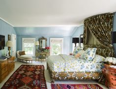 a bedroom with blue walls and carpeted flooring has a large bed in the center