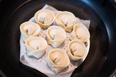 some dumplings are sitting in a black pan