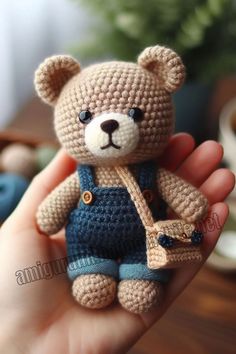 a small crocheted teddy bear wearing overalls