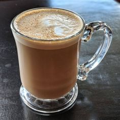 a glass mug filled with liquid sitting on top of a table