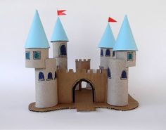 a castle made out of cardboard with red flags on the top and blue roof tops