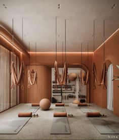 there are many yoga mats and exercise balls in this room with orange lighting on the walls