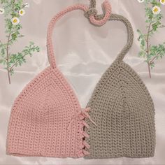 two crocheted bras on a white sheet with flowers in the back ground