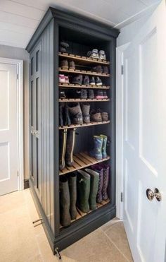 an open shoe cabinet with several pairs of boots on top and two doors to the other side