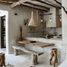 a rustic kitchen with white walls and wood accents on the ceiling, along with wooden benches