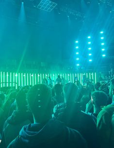 a large group of people standing in front of a stage with bright lights on it