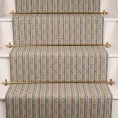 the stairs are decorated with blue and beige striped carpet