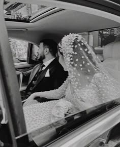 a bride and groom sitting in the back seat of a car