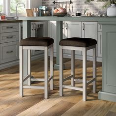 two stools sitting in front of a kitchen counter